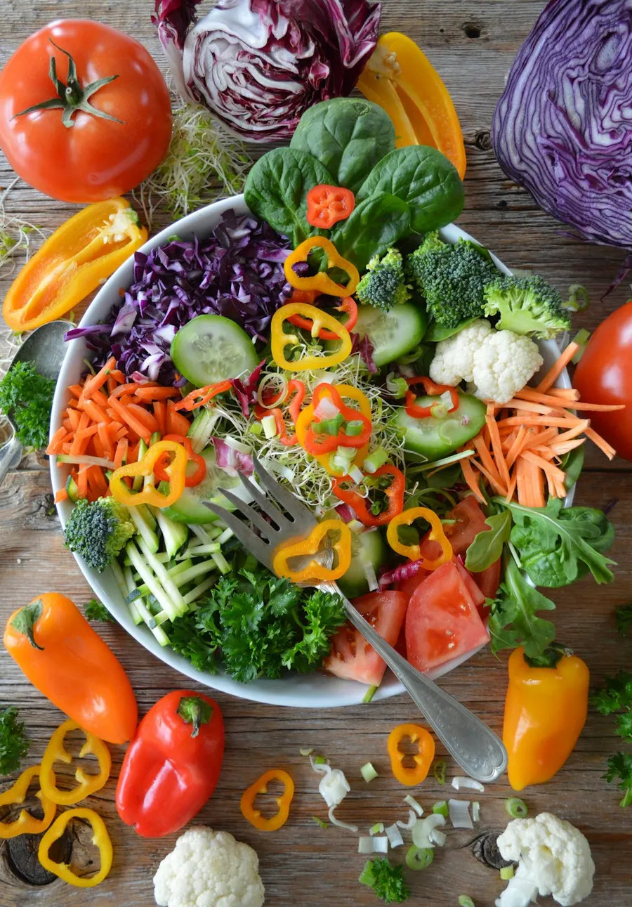 Fresh vegetables and salad ingredients laid out on a kitchen bench